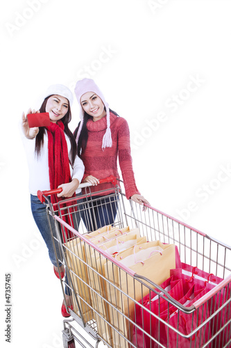 Photo: Happy winter shopping trolley with friend-isolated Happy winter shopping trolley with friend-isolated