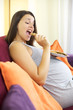 Pregnant woman eating cooky dessert happy