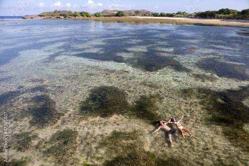 Photo: Couple lying on coast Bali, travel concept Couple lying on coast Bali, travel concept
