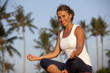Smiling woman sitting in pose lotus and looking at camera
