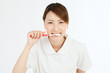 Beautiful young nurse cleaning teeth