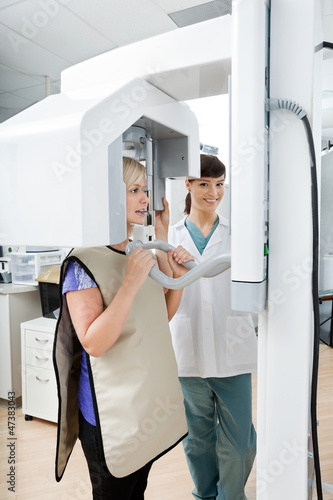 Photo: Female Dentist With Patient Getting Her Teeth X-Rayed At Clinic Female Dentist With Patient Getting Her Teeth X-Rayed At Clinic