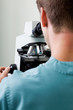 Male Researcher Using Microscope In Laboratory