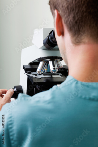 Photo: Male Researcher Using Microscope In Laboratory Male Researcher Using Microscope In Laboratory
