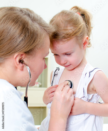 Photo: Female doctor examining little girl with stethoscope Female doctor examining little girl with stethoscope