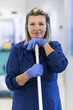 Portrait of happy professional female cleaner smiling in office