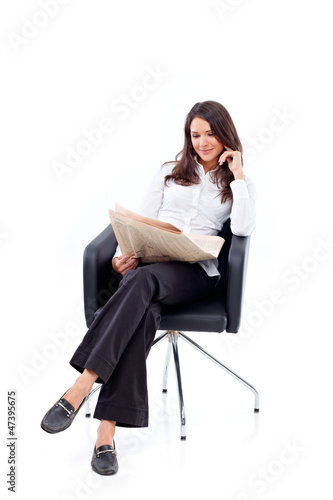 Photo: Casual 20s woman reading stock rates in newspaper 5 Casual 20s woman reading stock rates in newspaper 5