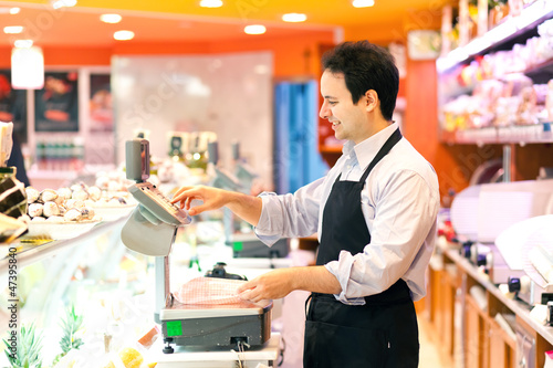 Photo: Butcher at work in a supermarket Butcher at work in a supermarket