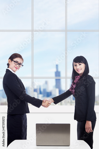 Photo: Business women partnership with laptop in office Business women partnership with laptop in office