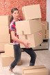 Woman struggling to carry boxes