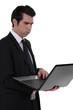 An unhappy businessman with a laptop.
