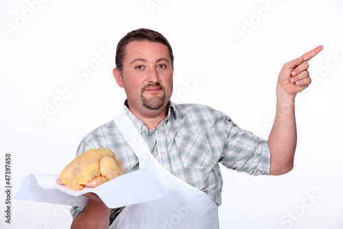 Photo: Butcher pointing with a chicken Butcher pointing with a chicken
