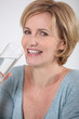Closeup of healthy woman drinking a glass of pure water