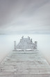 Wooden pier on lake in a cloudy and foggy mood.