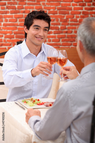 Photo: father and son having dinner in a restaurant father and son having dinner in a restaurant