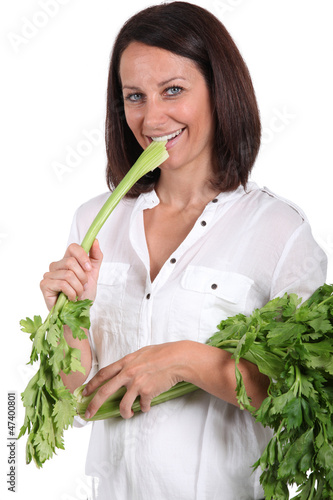 Photo: Woman eating a branch of celery Woman eating a branch of celery