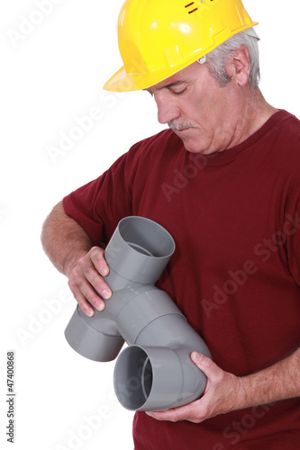 Photo: Plumber putting together waste pipes Plumber putting together waste pipes