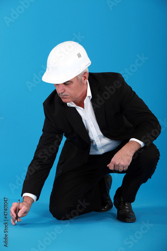 Photo: Engineer making markings on the floor Engineer making markings on the floor