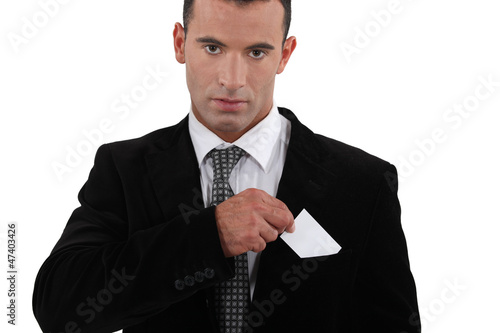 Photo: businessman putting a visit card in his pocket businessman putting a visit card in his pocket