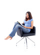 Young woman sitting in a chair with magazine