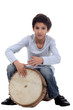Photo: Boy playing a djembe Boy playing a djembe