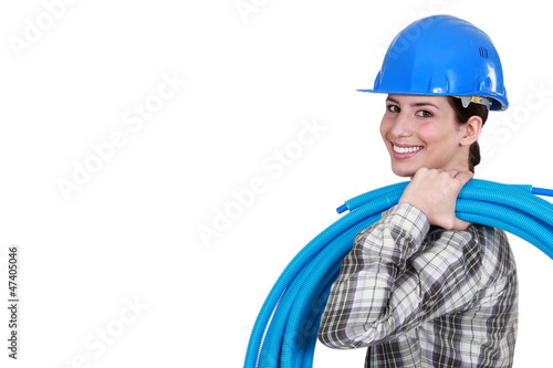 Photo: Female plumber carrying pipes Female plumber carrying pipes