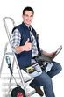 Foto: handyman with tools and a computer handyman with tools and a computer