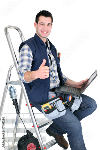 Photo: handyman with tools and a computer handyman with tools and a computer