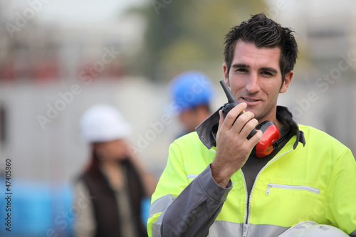 Photo: Traffic guard speaking into his walkie talkie Traffic guard speaking into his walkie talkie