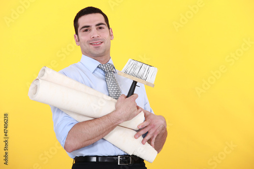 Photo: young handsome man carrying rolls of wallpaper young handsome man carrying rolls of wallpaper