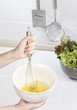 A woman stirring eggs to make some food