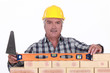 Bricklayer checking the level of a wall