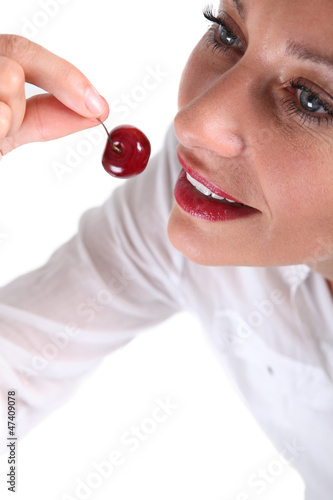 Photo: Woman about to bite a cherry Woman about to bite a cherry