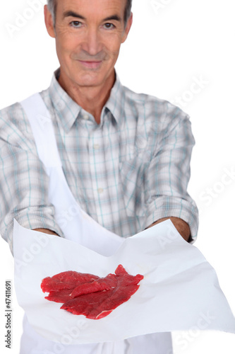 Photo: Butcher showing meat on white background Butcher showing meat on white background