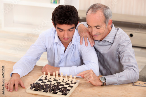 Photo: Father and son playing chess Father and son playing chess