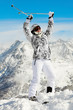 Young woman in ski suit stands  on top of hill
