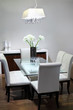 Simple room with glasses table with flowers and soft white chair