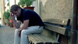 Sad man sitting on bench in the city