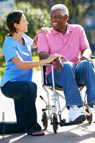 Photo: Carer Pushing Senior Man In Wheelchair Carer Pushing Senior Man In Wheelchair