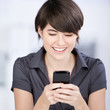 glückliche frau schaut auf ihr handy