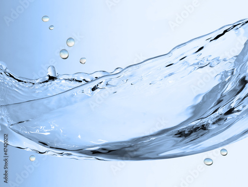 Photo: splashing water on air over blue splashing water on air over blue