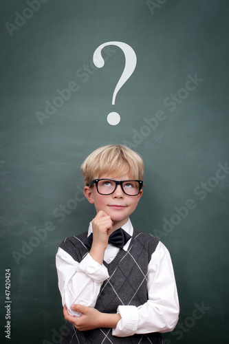 Photo: Schoolboy at the Blackboard with Questionmark Schoolboy at the Blackboard with Questionmark