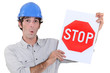 A road worker holding a stop sign.