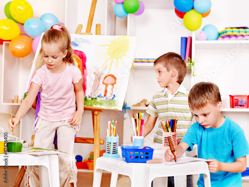 Photo: Child painting at easel. Child painting at easel.