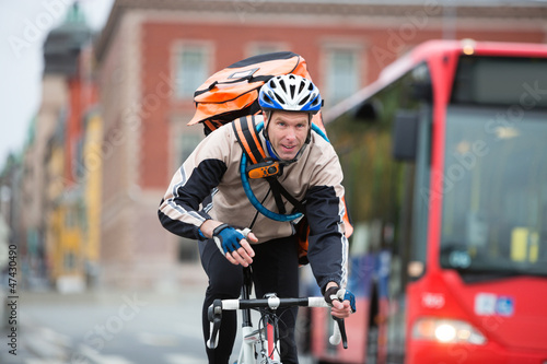 Photo: Male Cyclist With Courier Delivery Bag Riding Bicycle Male Cyclist With Courier Delivery Bag Riding Bicycle