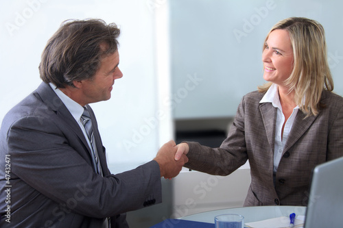 Photo: Zufriedene Geschäftspartner geben sich die Hand Zufriedene Geschäftspartner geben sich die Hand