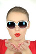 Woman with glasses pulling air kiss