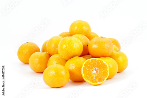 Photo: Tangerines heap with one halved showing juicy centre, isolated Tangerines heap with one halved showing juicy centre, isolated