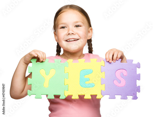 Photo: Cute little girl is holding Yes slogan Cute little girl is holding Yes slogan