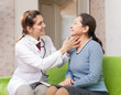 Doctor touching neck of  patient